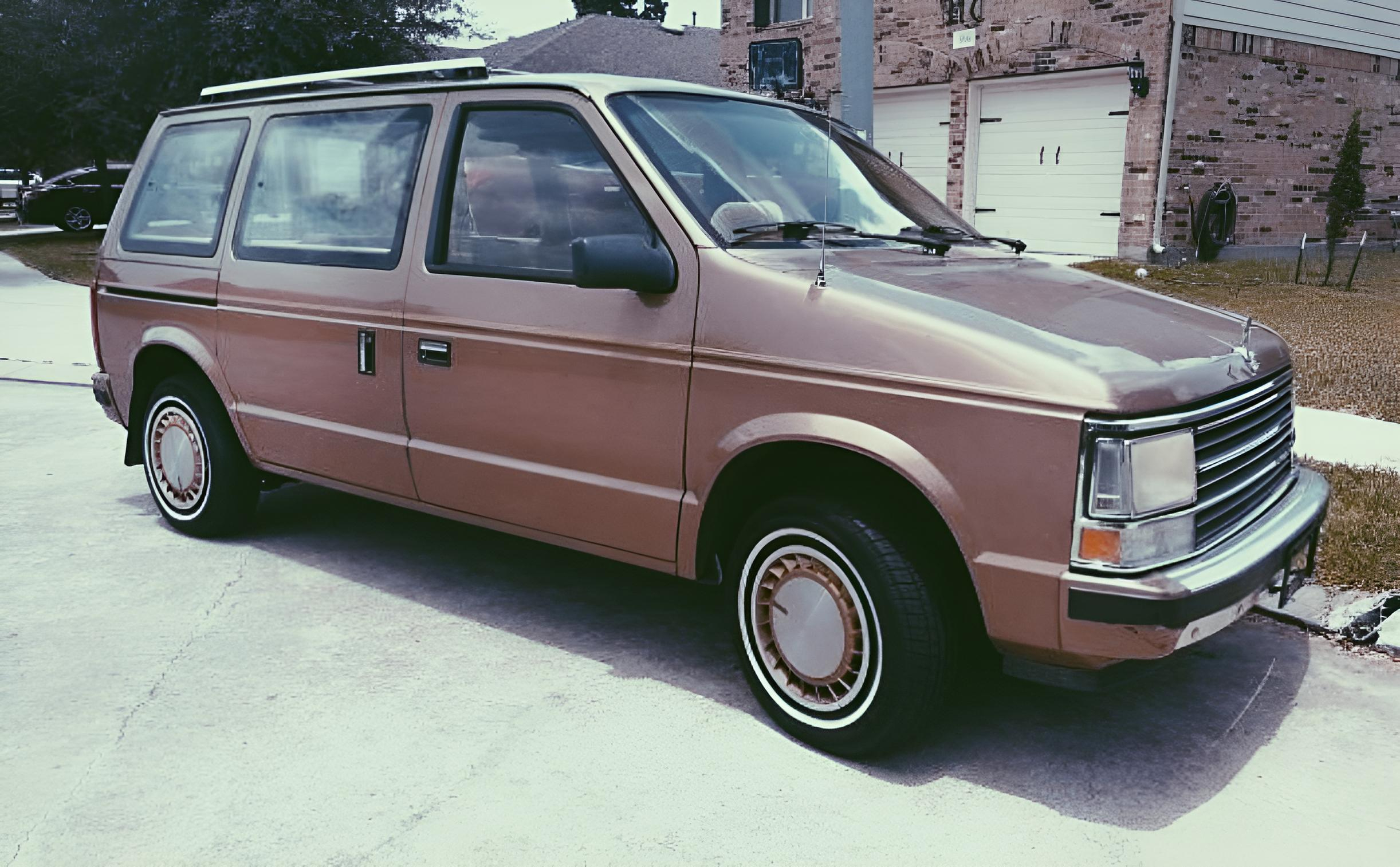 dodge caravan devant une maison, retouché par IA