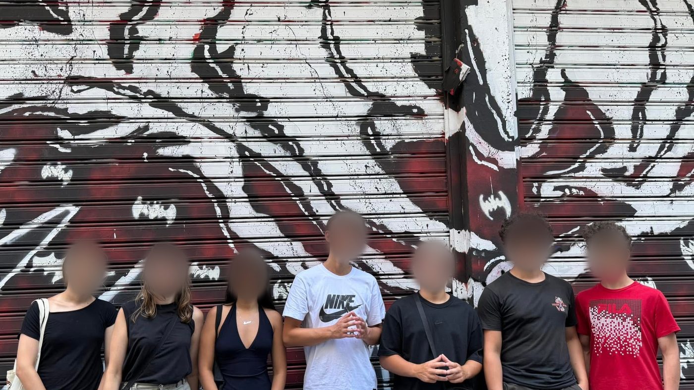 Des élèves devant un mur de graffitis à Athènes