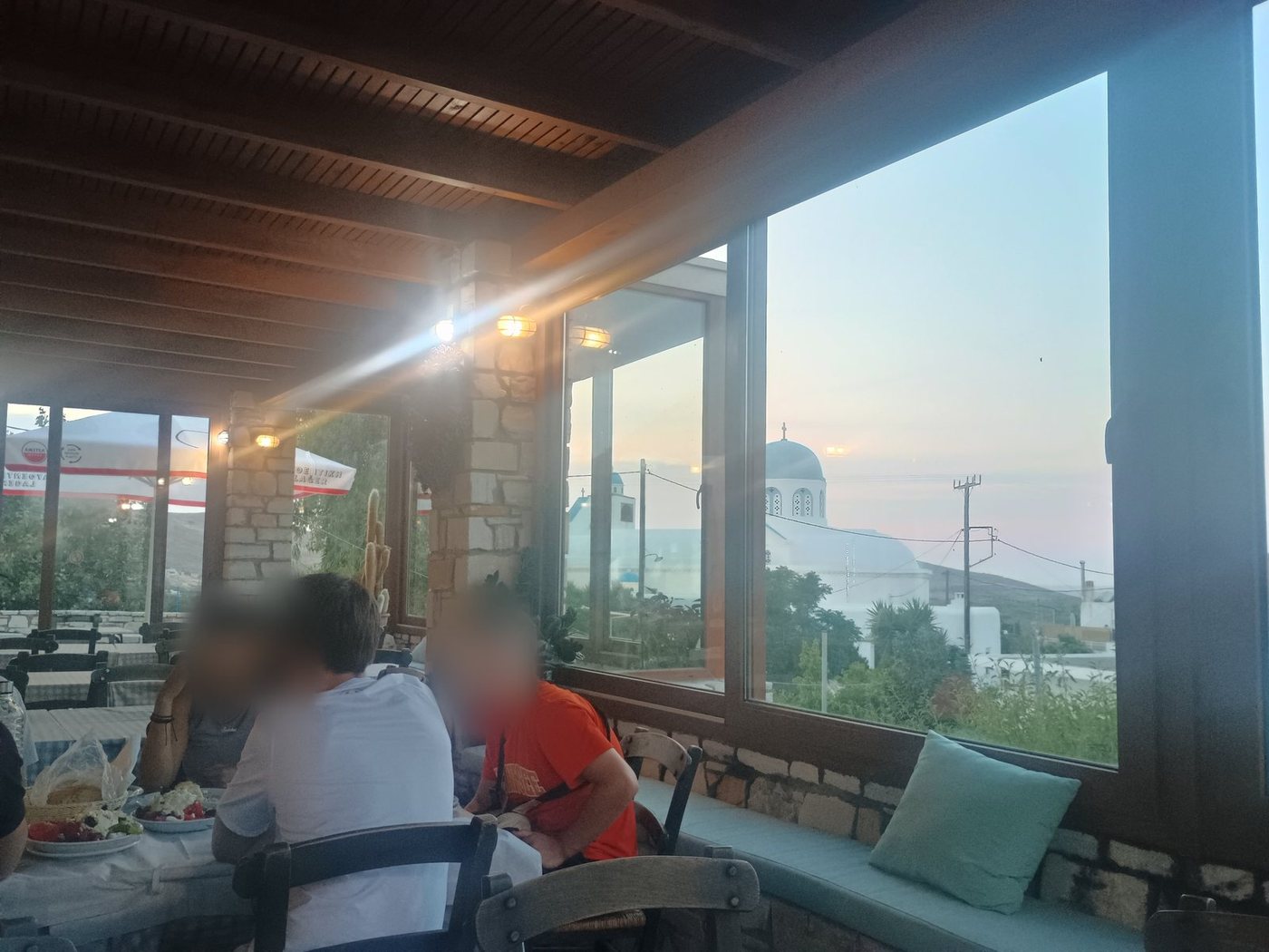 Une table près de la fenêtre d'une taverne au coucher du soleil, à Naxos