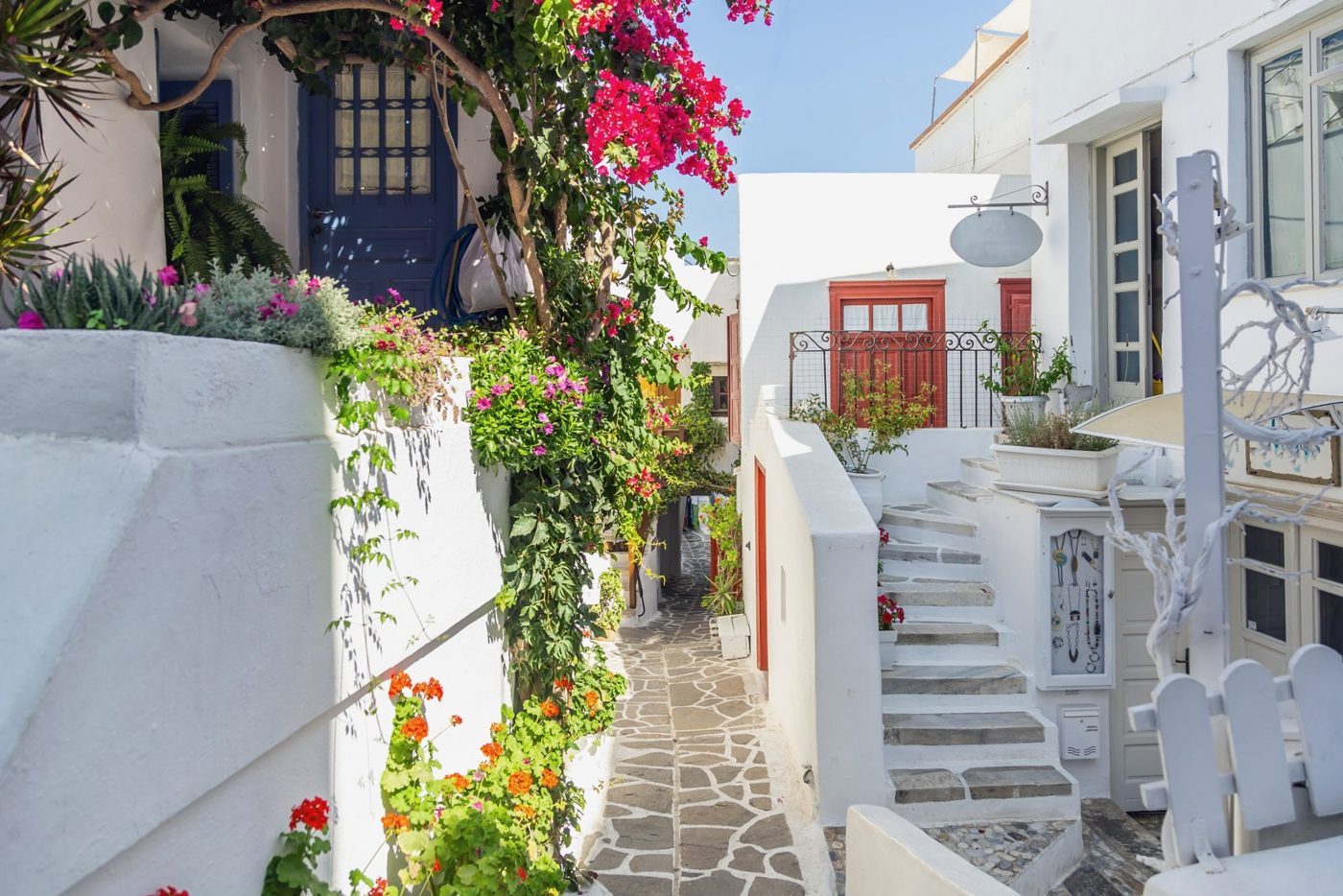 Bougainvilliers et maisons blanchies dans une ruelle pavée de la ville de Naxos