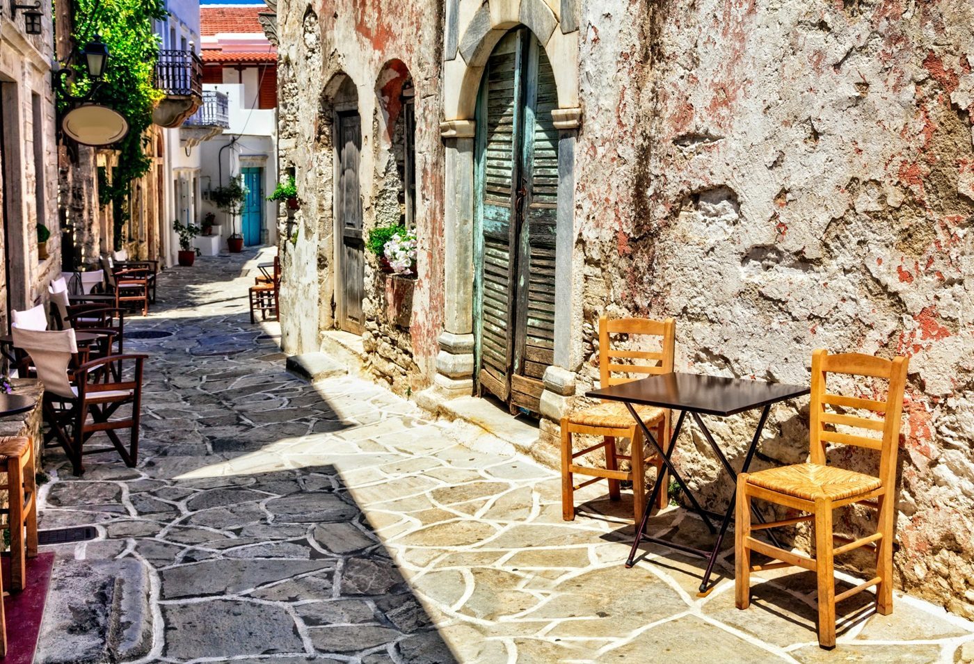 Tables de café dans une ruelle de pierre à Halki, l'ancienne capitale de l'intérieur de Naxos