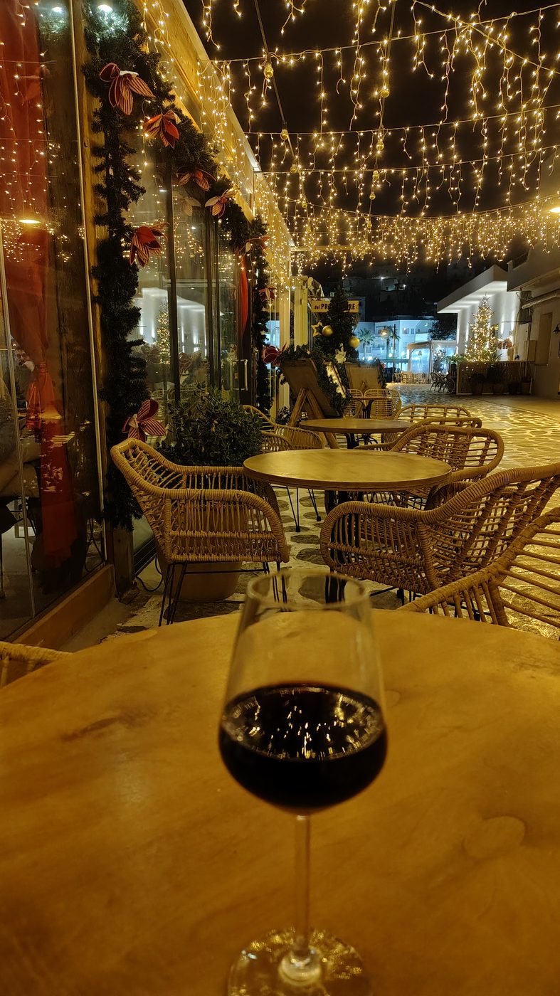Des tables de café sous les guirlandes lumineuses, sur le front de mer de Naxos