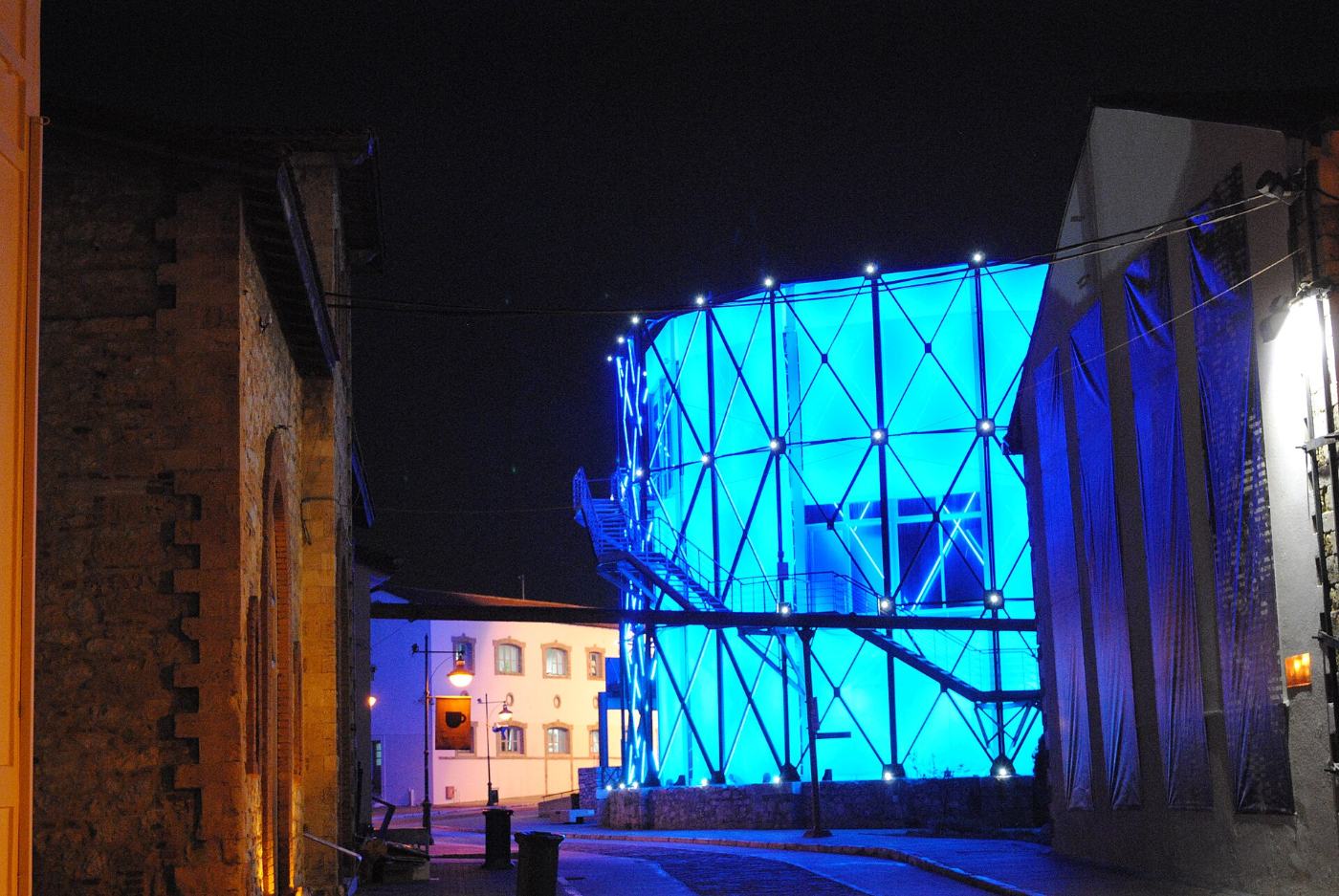 Le gazomètre illuminé en bleu la nuit